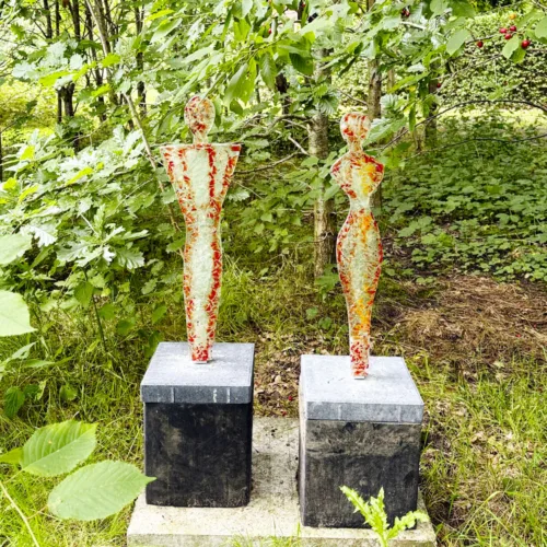 Orangegule skulpturer i glas forestillende 2 mennesker