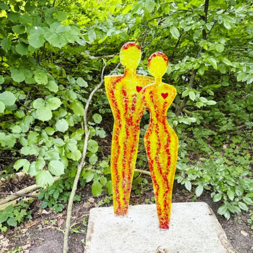 Orangegule skulpturer i glas forestillende 2 mennesker