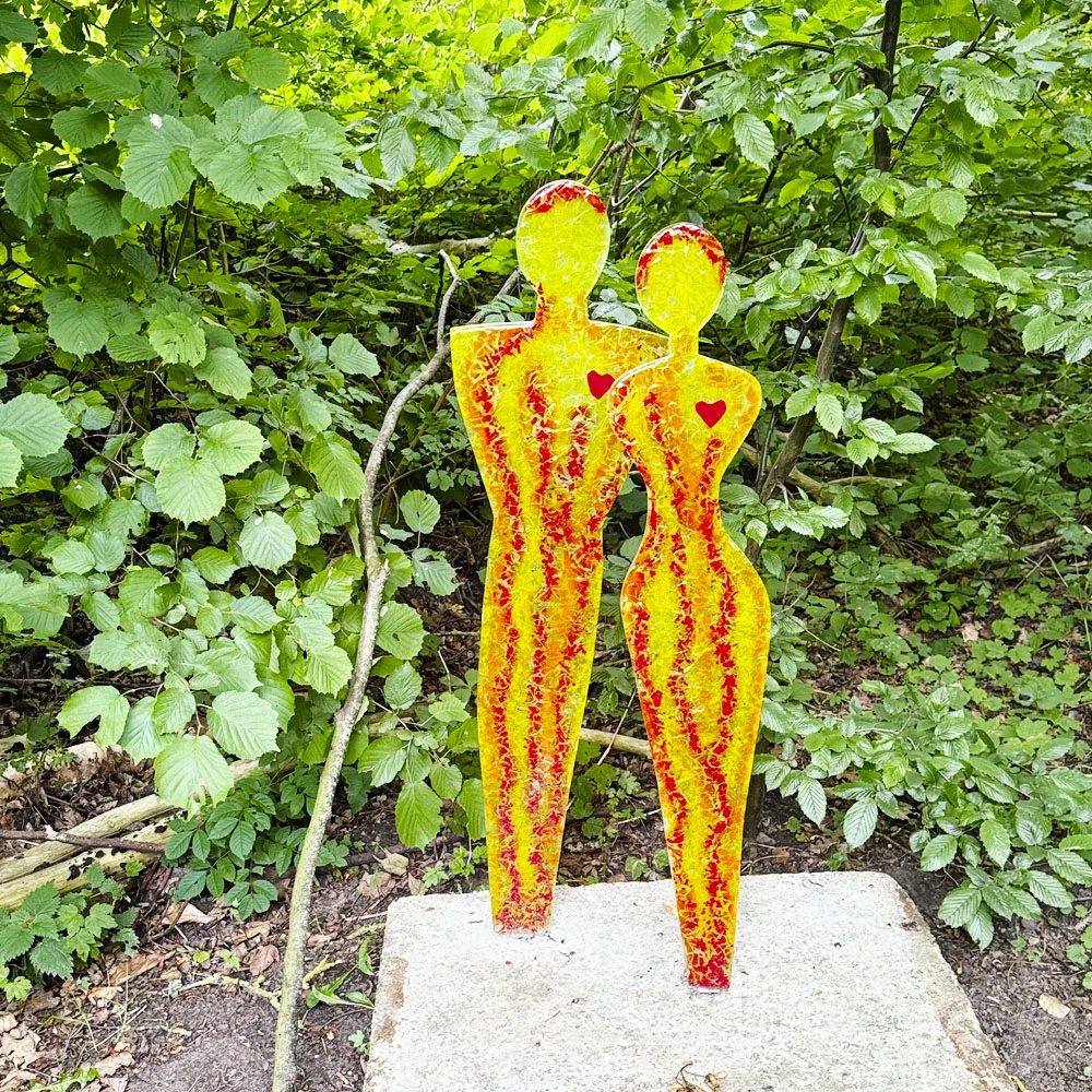 Orangegule skulpturer i glas forestillende 2 mennesker