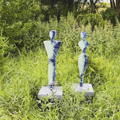 Orangegule skulpturer i glas forestillende 2 mennesker