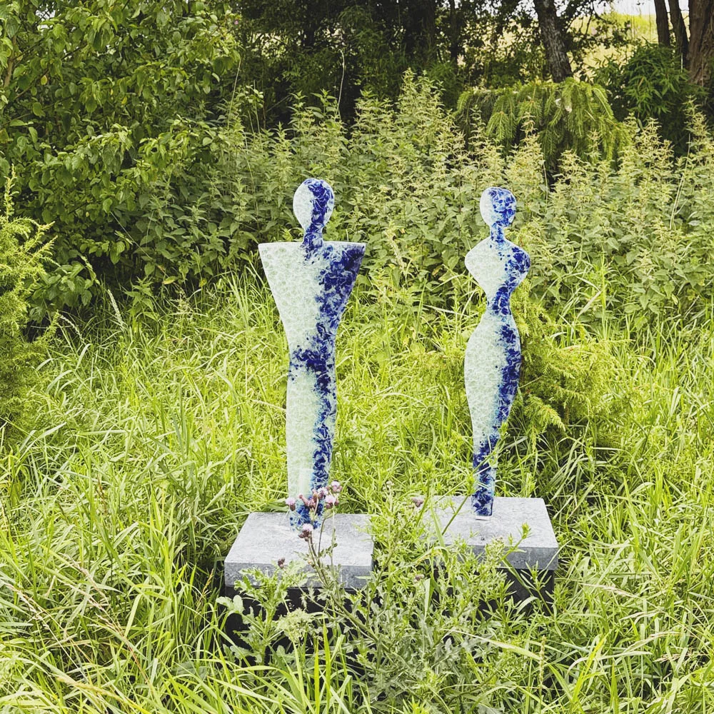 Orangegule skulpturer i glas forestillende 2 mennesker